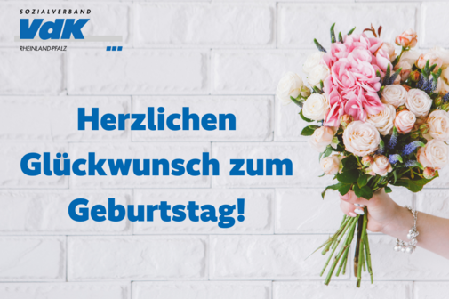 Hand mit einem Blumenstrauß als Geburtstagswünsche