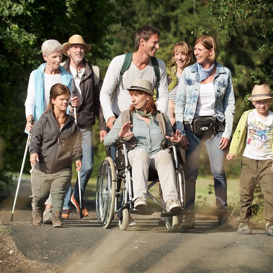 Der VdK Eine Gruppe Menschen spaziert über einen Weg.